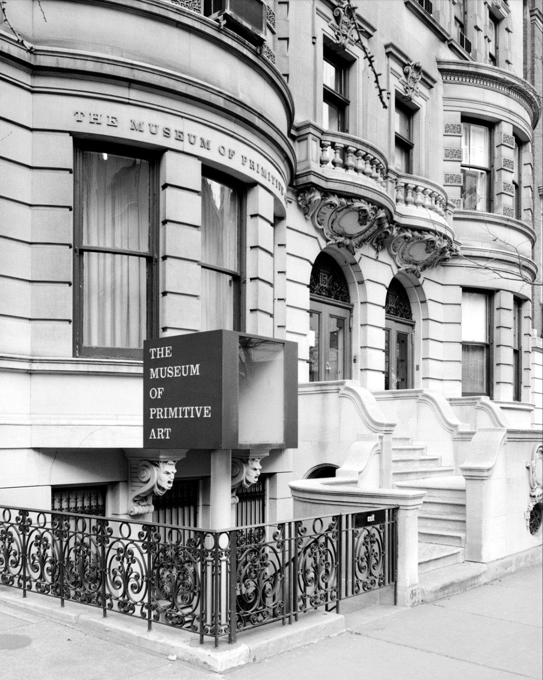 A black-and-white photograph of a multistory brownstone building with a sign that reads “The Museum of Primitive Art.”